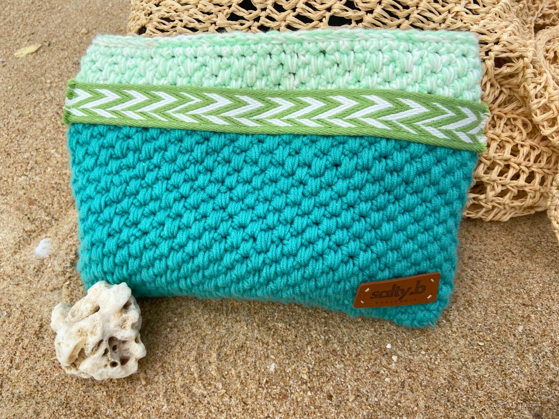 Turquoise zipper pouch on sand