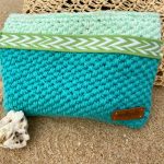 Turquoise zipper pouch on sand